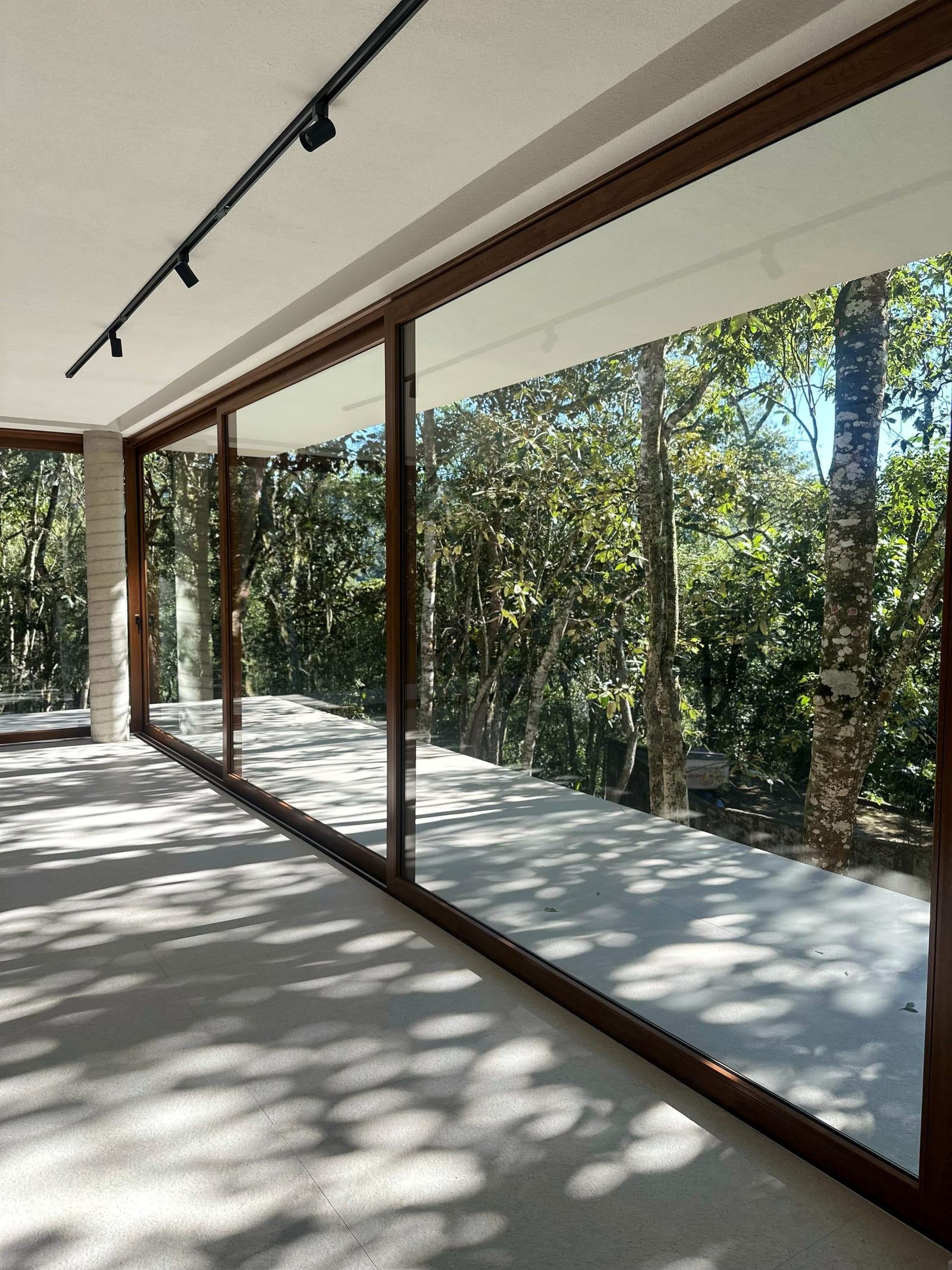 Interior com a floresta refletida no vidro